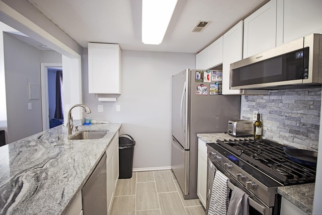 105 Little Oak Ln Unit 105, Rocky Hill, CT 06067 - kitchen with appliances with stainless steel finishes, tasteful backsplash, light stone countertops, and white cabinets