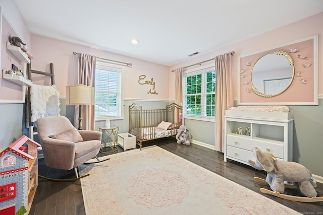 126 Sutton Dr E, Stamford, CT 06906 - bedroom featuring multiple windows, wood finished floors, and a crib
