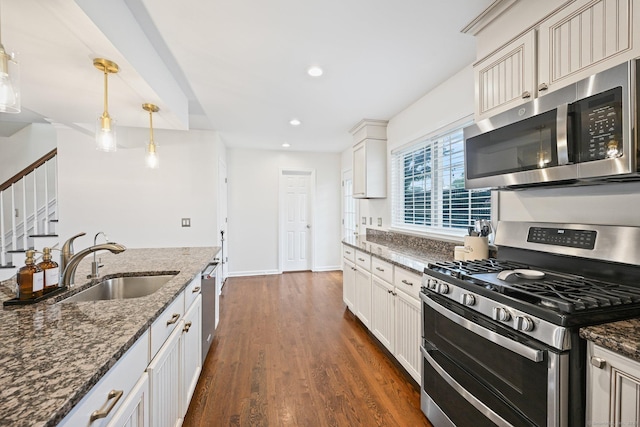 126 Sutton Dr E, Stamford, CT 06906 - kitchen featuring appliances with stainless steel finishes, recessed lighting, dark stone counters, dark wood finished floors, and decorative light fixtures