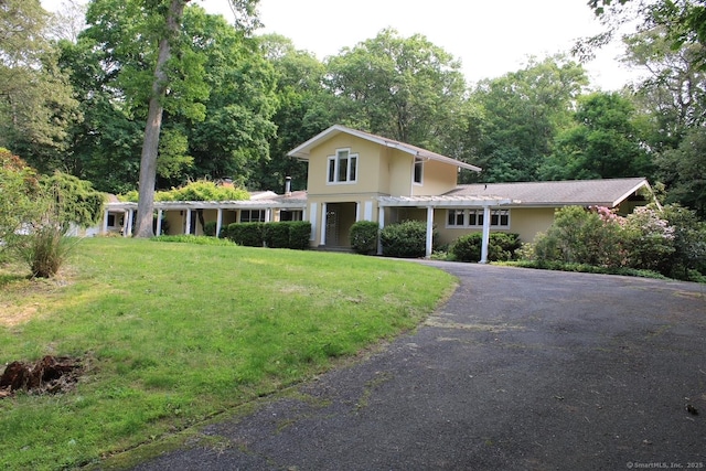 20 Shady Acres Rd, Darien, CT 06820 - view of front of home with driveway, a front lawn, stucco siding, and view of wooded area