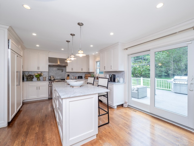 565 Danbury Rd, Wilton, CT 06897 - kitchen featuring high end appliances, wall chimney exhaust hood, decorative backsplash, light wood-style floors, and recessed lighting