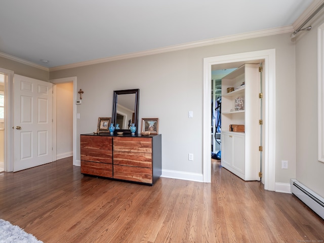 565 Danbury Rd, Wilton, CT 06897 - bedroom with a baseboard radiator, wood finished floors, a spacious closet, and ornamental molding