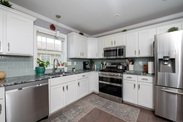 5 Pope St, New Haven, CT 06512 - kitchen featuring appliances with stainless steel finishes, white cabinetry, crown molding, decorative backsplash, and dark wood-style flooring