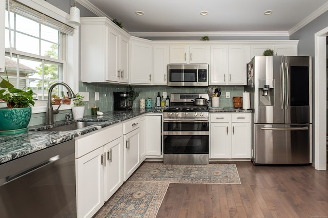 5 Pope St, New Haven, CT 06512 - kitchen featuring appliances with stainless steel finishes, ornamental molding, dark wood-type flooring, white cabinetry, and dark stone counters
