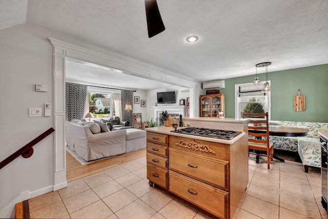 35 Twelve Acre Ln, Glastonbury, CT 06033 - kitchen featuring a wall unit AC, stainless steel gas stovetop, a textured ceiling, open floor plan, and light tile patterned floors