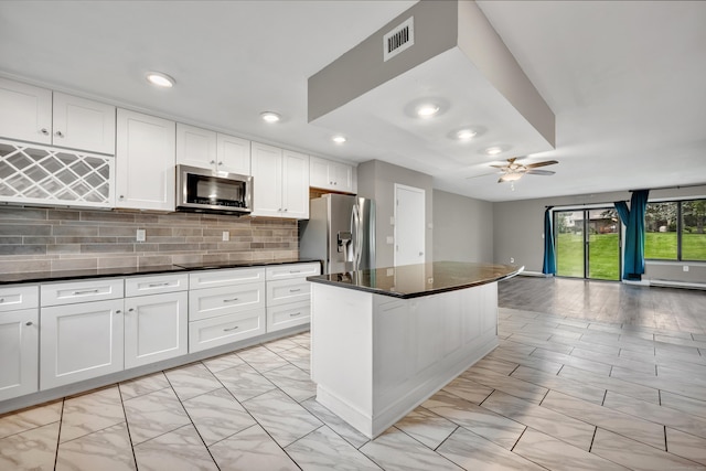 16 Pine Ct Unit 16, Cromwell, CT 06416 - kitchen with stainless steel appliances, ceiling fan, open floor plan, white cabinetry, and tasteful backsplash