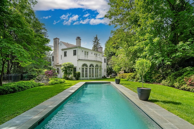 34 Edgewood Dr, Greenwich, CT 06831 - back of property with french doors, a chimney, a balcony, and an outdoor pool