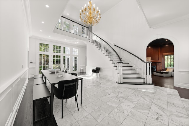 34 Edgewood Dr, Greenwich, CT 06831 - dining room featuring a decorative wall, stairs, crown molding, a chandelier, and arched walkways
