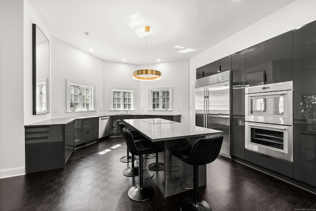 34 Edgewood Dr, Greenwich, CT 06831 - kitchen featuring appliances with stainless steel finishes, a kitchen bar, light countertops, a kitchen island, and modern cabinets