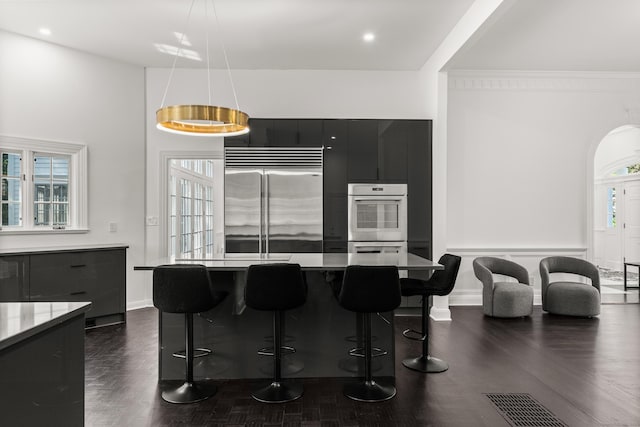 34 Edgewood Dr, Greenwich, CT 06831 - kitchen with stainless steel built in refrigerator, dark cabinetry, dark wood-style floors, white double oven, and modern cabinets