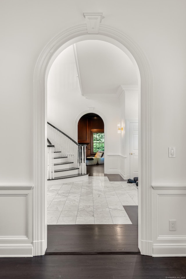 34 Edgewood Dr, Greenwich, CT 06831 - foyer featuring arched walkways, a decorative wall, stairs, wainscoting, and marble finish flooring