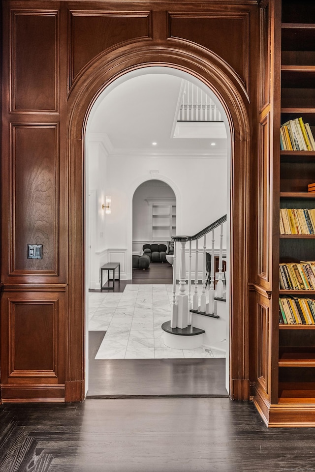 34 Edgewood Dr, Greenwich, CT 06831 - hallway featuring arched walkways, built in shelves, crown molding, and stairs