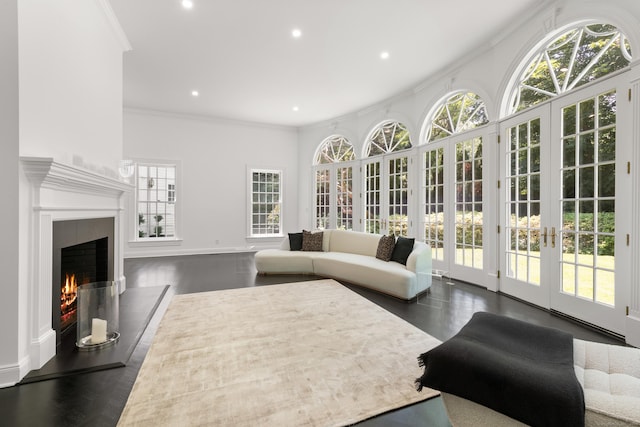 34 Edgewood Dr, Greenwich, CT 06831 - living room with french doors, ornamental molding, recessed lighting, a warm lit fireplace, and wood finished floors