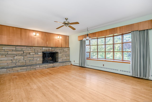 24 Warwick Rd, New Fairfield, CT 06812 - unfurnished living room featuring a ceiling fan, wood finished floors, a baseboard radiator, and a stone fireplace
