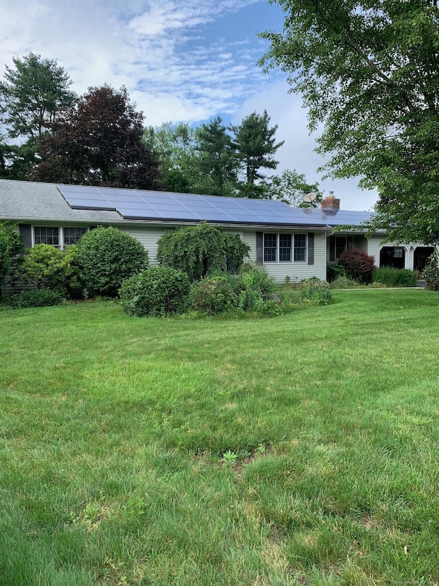 180 Round Hill Rd, Cheshire, CT 06410 - view of front facade featuring a front yard, a chimney, and roof mounted solar panels