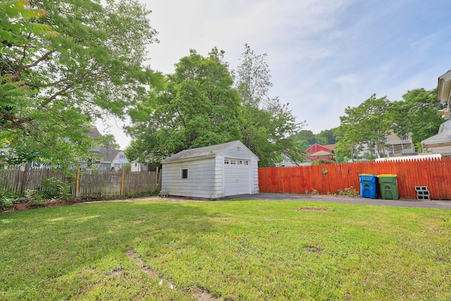 42 Marlboro St, Waterbury, CT 06705 - fenced backyard with an outdoor structure, a detached garage, and asphalt driveway