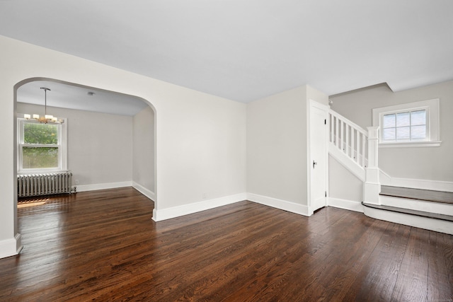 42 Marlboro St, Waterbury, CT 06705 - unfurnished room featuring radiator, arched walkways, wood finished floors, and a chandelier