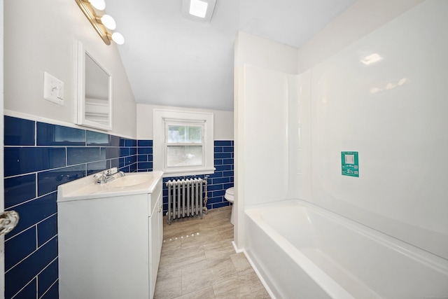 42 Marlboro St, Waterbury, CT 06705 - bathroom with radiator heating unit, tile walls, vanity, tub / shower combination, and a wainscoted wall
