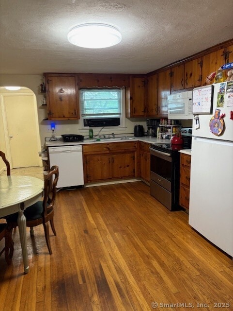 31 Happy St, Norwich, CT 06360 - kitchen with white appliances, light countertops, a textured ceiling, wood finished floors, and arched walkways