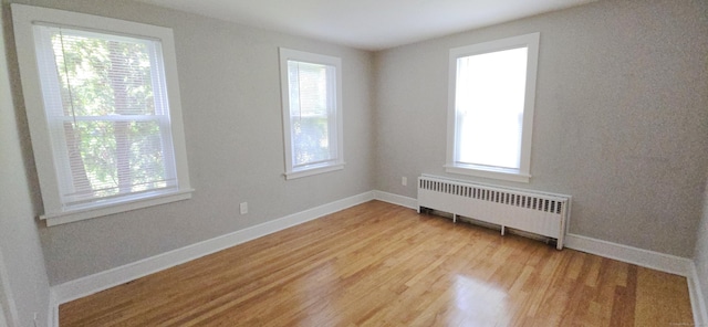 20 Old Stafford Rd, Tolland, CT 06084 - empty room featuring radiator heating unit, plenty of natural light, and light wood finished floors