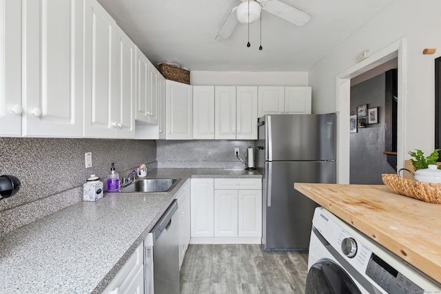 208 Flax Hill Rd Apt 10, Norwalk, CT 06854 - kitchen with appliances with stainless steel finishes, washer / dryer, white cabinets, and light wood-type flooring