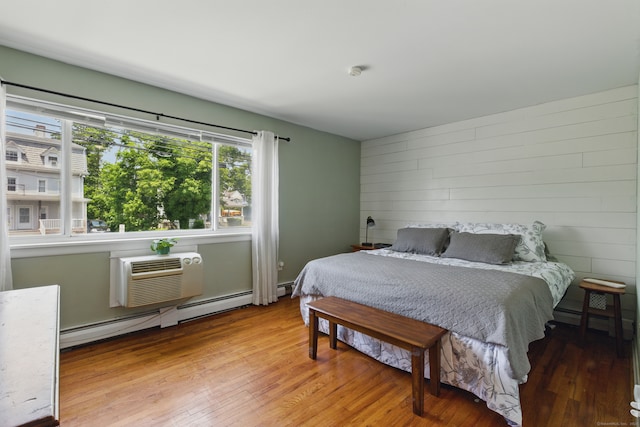 208 Flax Hill Rd Apt 10, Norwalk, CT 06854 - bedroom featuring wood finished floors, a wall mounted AC, a baseboard heating unit, and wooden walls