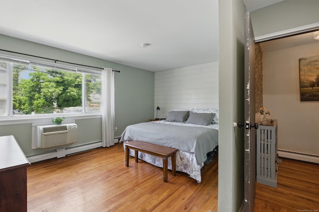 208 Flax Hill Rd Apt 10, Norwalk, CT 06854 - bedroom featuring a baseboard heating unit, wood finished floors, baseboard heating, and a wall mounted AC