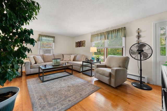 135 Liberty St Unit 135, Clinton, CT 06413 - living area featuring baseboard heating, plenty of natural light, a textured ceiling, wood finished floors, and cooling unit