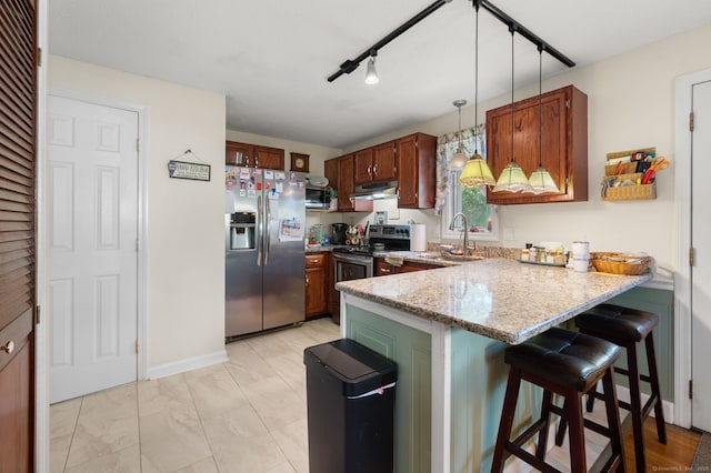 135 Liberty St Unit 135, Clinton, CT 06413 - kitchen featuring appliances with stainless steel finishes, a peninsula, hanging light fixtures, under cabinet range hood, and a kitchen bar