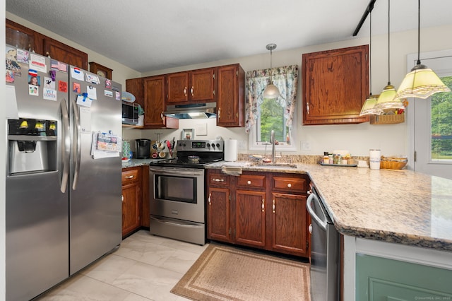 135 Liberty St Unit 135, Clinton, CT 06413 - kitchen featuring stainless steel appliances, light marble finish flooring, under cabinet range hood, hanging light fixtures, and brown cabinets
