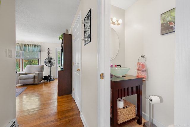 135 Liberty St Unit 135, Clinton, CT 06413 - corridor with wood finished floors and a baseboard heating unit