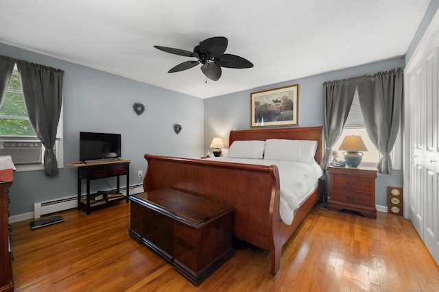 135 Liberty St Unit 135, Clinton, CT 06413 - bedroom with wood-type flooring, cooling unit, a closet, baseboard heating, and a ceiling fan