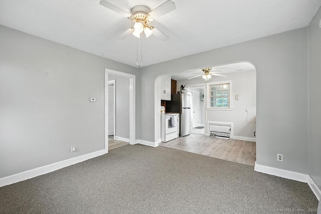 85 Peck St, Berlin, CT 06037 - unfurnished living room with arched walkways, a ceiling fan, and light colored carpet