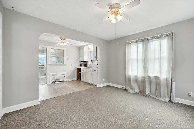 85 Peck St, Berlin, CT 06037 - unfurnished living room featuring arched walkways, ceiling fan, light carpet, and plenty of natural light