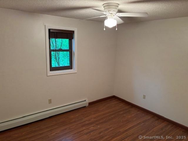 56 Cedar Swamp Rd, Mansfield, CT 06268 - spare room with baseboard heating, dark wood-style floors, a ceiling fan, and a textured ceiling