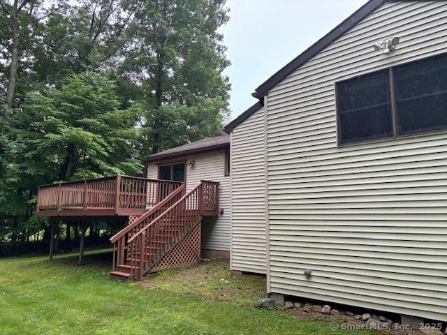 56 Cedar Swamp Rd, Mansfield, CT 06268 - view of property exterior featuring a wooden deck, a lawn, and stairs