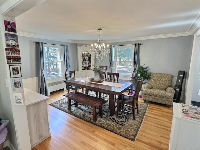 4380 Whitney Ave, Hamden, CT 06518 - dining area featuring radiator, crown molding, plenty of natural light, a chandelier, and light wood-style floors