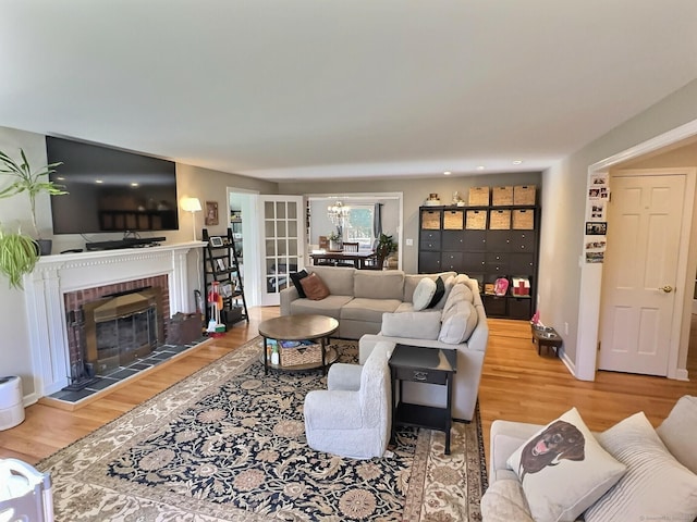 4380 Whitney Ave, Hamden, CT 06518 - living area with wood finished floors, a brick fireplace, and a chandelier