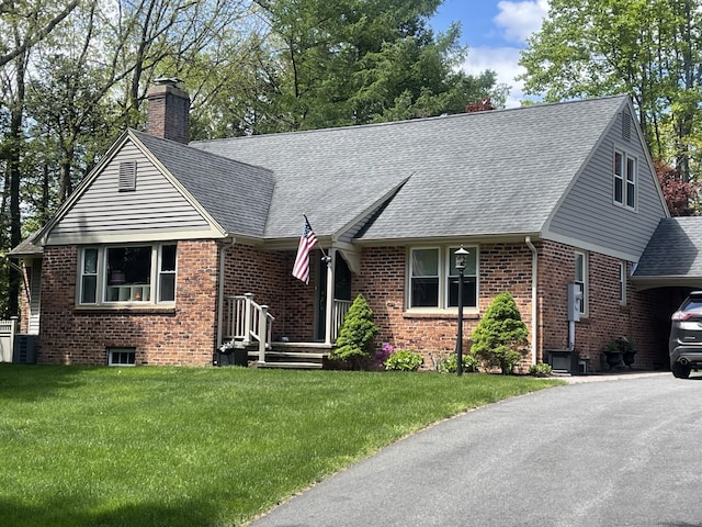4380 Whitney Ave, Hamden, CT 06518 - view of front facade featuring a chimney, brick siding, roof with shingles, driveway, and a front yard