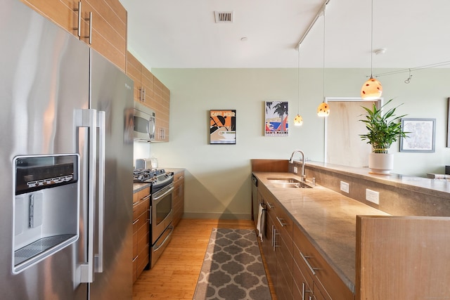 33 N Water St Unit 505, Norwalk, CT 06854 - kitchen with stainless steel appliances, a peninsula, brown cabinets, and wood finished floors