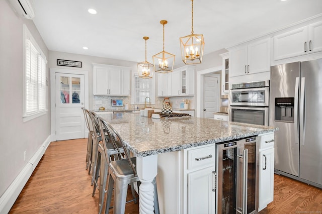 1676 Boulevard Blvd, West Hartford, CT 06107 - kitchen with stainless steel appliances, wine cooler, a chandelier, an AC wall unit, and white cabinetry