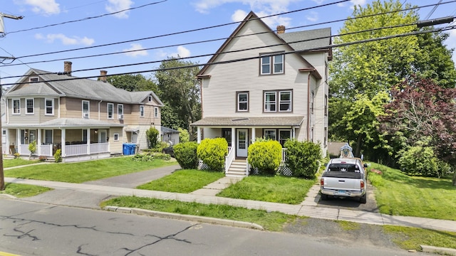 116 Divinity St, Bristol, CT 06010 - view of front facade with a porch, a front lawn, and a chimney