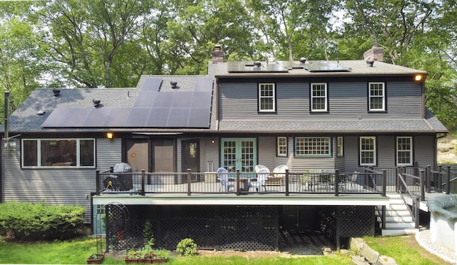 17 Kathleen Dr, Stratford, CT 06614 - back of property featuring a chimney, french doors, roof mounted solar panels, and a wooden deck