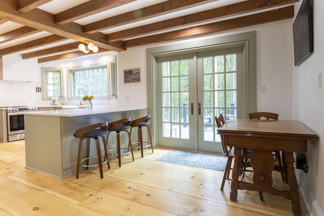 17 Kathleen Dr, Stratford, CT 06614 - kitchen featuring stainless steel range with electric cooktop, french doors, healthy amount of natural light, beam ceiling, and a peninsula