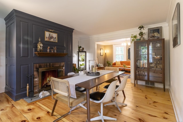 17 Kathleen Dr, Stratford, CT 06614 - dining room featuring a chandelier, a brick fireplace, light wood-type flooring, and ornamental molding