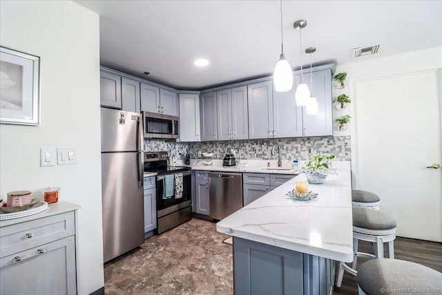 59 Courtland Ave Apt 3Q, Stamford, CT 06902 - kitchen featuring stainless steel appliances, a kitchen breakfast bar, a peninsula, gray cabinets, and tasteful backsplash