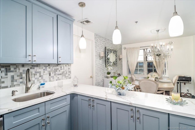 59 Courtland Ave Apt 3Q, Stamford, CT 06902 - kitchen with decorative backsplash, a chandelier, decorative light fixtures, light stone counters, and a peninsula