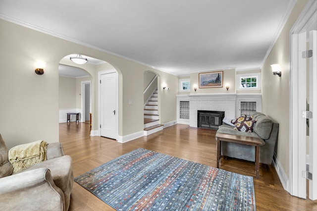 35 Brower St, West Haven, CT 06516 - living area featuring arched walkways, ornamental molding, wood finished floors, a brick fireplace, and stairs