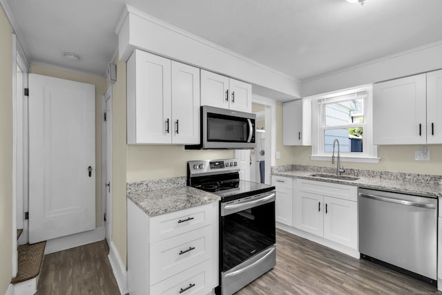 35 Brower St, West Haven, CT 06516 - kitchen featuring appliances with stainless steel finishes, dark wood-style floors, light stone counters, white cabinets, and crown molding