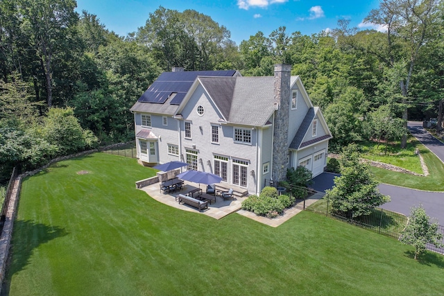 319 Mountain Rd, Wilton, CT 06897 - back of house with solar panels, a chimney, a patio, an attached garage, and outdoor dining space